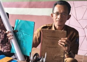 Kades Kemuning Sopwanudin menunjukkan dokumen kepemilikan lahan Rawa Pasar Raut dan Rawa Enang yang disebut milik masyarakat, bukan aset Pemprov Banten.
Sumber foto: Bantenraya.co.id
