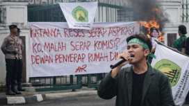 Seorang mahasiswa IMALA menyampaikan orasi menggunakan pengeras suara di depan gerbang DPRD Kabupaten Lebak, Rabu (4/3/2026), dalam aksi menolak kenaikan dana reses 22,8 persen. (Foto: Dok. IMALA/Istimewa/Bantenpopuler.com)